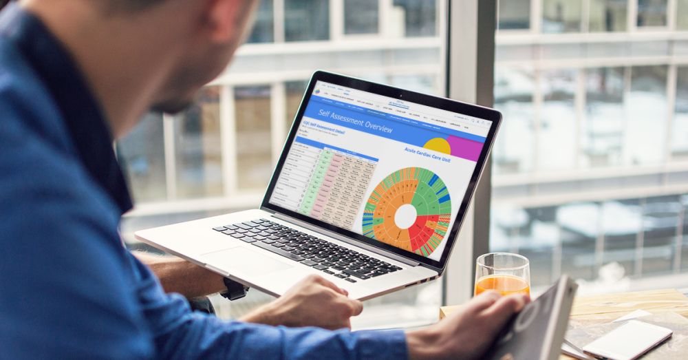a man looking at a the inphase oversight quality app on a laptop