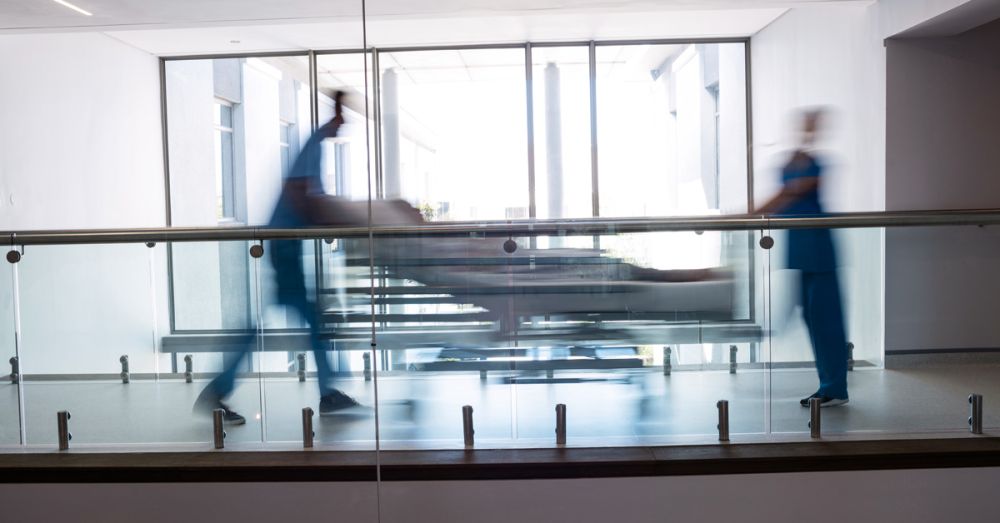 staff pushing patient in bed down corridor easurance teaser image