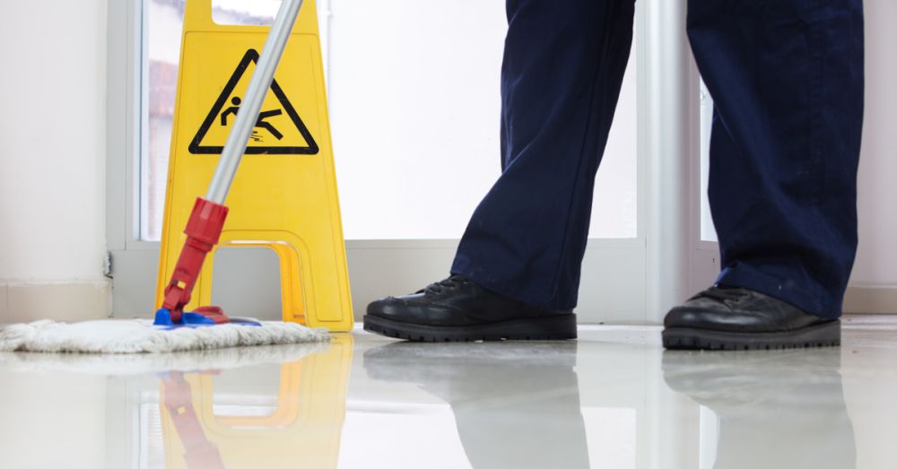 mopping wet floor next to a wet floor sign