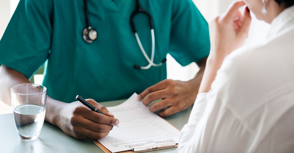 a doctor and patient at a desk running through a checklist